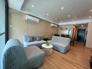 a living room with two couches and a table at Subic Sweet Escape by Bonnie in Olongapo