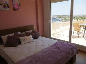 1 dormitorio con 1 cama y vistas a un balcón en Excelente Duplex en Altaona golf resort-piscinas, en Murcia