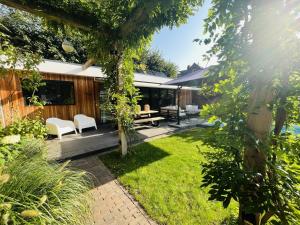 einen Garten mit einer Terrasse und einem Haus in der Unterkunft Bed and Breakfast 013 city in Tilburg