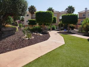 ムルシアにあるExcelente Duplex en Altaona golf resort-piscinasの木々と建物のある庭の歩道