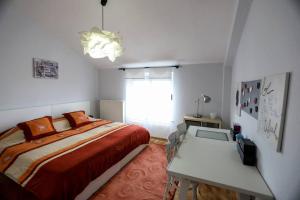 a bedroom with a bed and a desk and a window at Lovely Loft City Center Korca #8 in Korçë