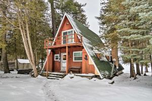 een hut in het bos in de sneeuw bij Cozy Deer Lake Cabin, 3 Mi to Boyne Mtn Resort! in Boyne City