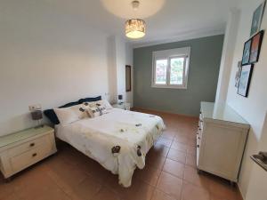 莫夕亞的住宿－Excelente Duplex en Altaona golf resort-piscinas，卧室设有一张白色大床和一扇窗户。