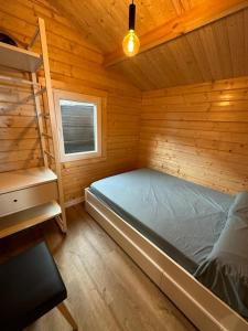 a bedroom with a bed in a wooden cabin at Cabaña Juanito del Roque in Valsequillo