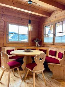 a dining room with a table and chairs in a cabin at Chalet Kleinbergsonne in Filzmoos