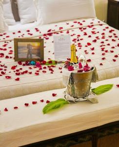 a bed with flower petals on it with a trophy on it at Beija Flor Exclusive Hotel & Spa in Pipa