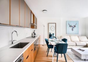 紐約的住宿－Stunning 2 BED 2 BA At UES，厨房以及带桌子和沙发的客厅。