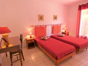 a bedroom with two beds and a table and a desk at Gite de la mousque in Castets