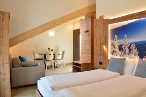 a hotel room with a bed and a table at Aria Alpina Guest House Affittacamere in Predazzo