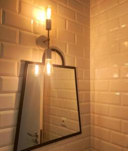 a mirror in a bathroom with a light and a lamp at Nice View Apartment in the city center in Fuzeta