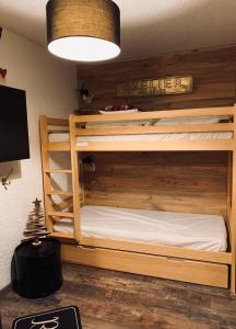 a bedroom with two bunk beds and a television at 2 alpes in Les Deux Alpes