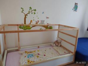 a toy bed with a tree and a teddy bear at Lovely 3-room condo in Berlin, lakes & city center in Berlin