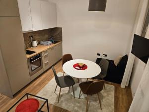 a small kitchen with a white table and chairs at Apartman Oki in Belgrade +9 photos
