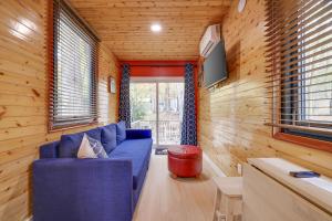 a living room with a blue couch in a tiny house at Camptel Poconos in Albrightsville