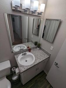 a bathroom with a sink and a toilet and a mirror at 2 Bed 2 Bath with pool and spa in Phoenix