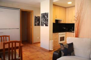 a kitchen with a couch and a chair in a room at Apartamento Gis con chimenea in Ribes de Freser