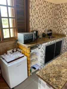 a kitchen with a counter top with a microwave at Chácara De Paula in Vassouras
