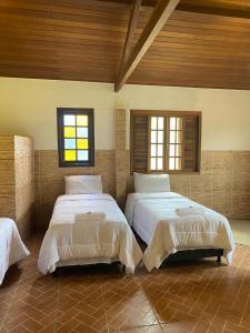 a large room with two beds in it at Chácara De Paula in Vassouras