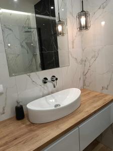 a bathroom with a white sink and a mirror at Apartamenty Bartoszyce 3 in Bartoszyce