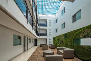 an internal courtyard of a building with chairs and plants at Gamma Puebla Señorial Centro in Puebla