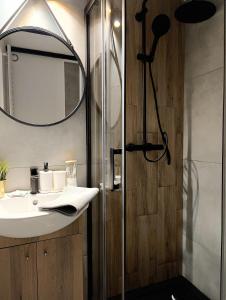 a bathroom with a sink and a shower at Hola Apartamenty Nawrot in Łódź