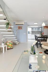 Biały salon ze stołem i schodami w obiekcie Beachfront Apartment Las Burras MRA 02 w mieście San Agustin
