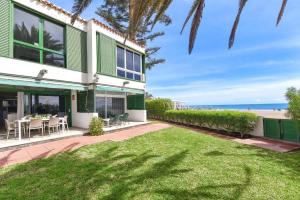 zewnętrzny widok na dom z trawnikiem i plażę w obiekcie Beachfront Apartment Las Burras MRA 02 w mieście San Agustin