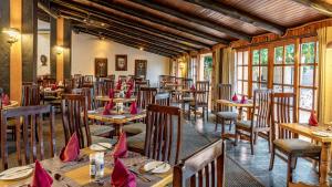 白河African Sky Hotels - Pine Lake Inn的餐厅配有桌椅和红色餐巾