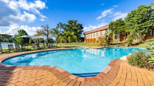 ein großer Pool mit einem Backsteinweg um ihn herum in der Unterkunft African Sky Hotels - Pine Lake Inn in White River