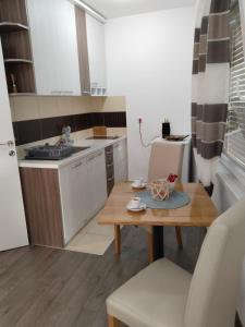 una piccola cucina con tavolo in legno in una stanza di Apartman Harmony 2 a Banja Koviljača