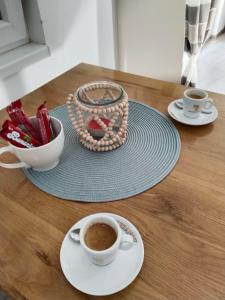 un tavolo con due tazze di caffè e una ciotola di fagioli di Apartman Harmony 2 a Banja Koviljača