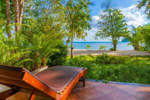 a bench sitting on a patio with a view of the ocean at Chivapuri Beach Resort in Ko Chang