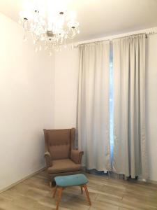 a chair and a chandelier in a living room at Z-1 Kraków Old Town O&P ApartFamily in Kraków