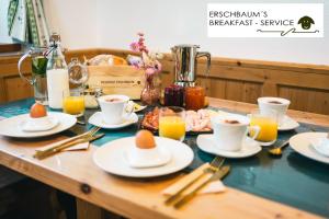 une table avec des assiettes de nourriture et des tasses de café dans l'établissement Residenz Erschbaum, à Valdaora