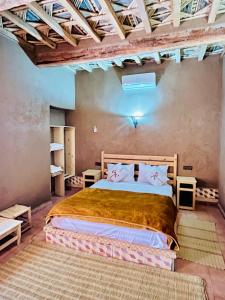 Camping auberge palmeraie d'amezrou في زاكورة: غرفة نوم بسرير كبير في غرفة