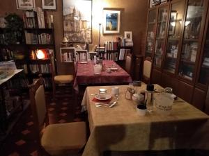 una sala da pranzo con due tavoli in una stanza con libri di Casa Irene a Torri di Quartesolo