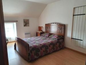 ein Schlafzimmer mit einem großen Bett in einem Zimmer in der Unterkunft Logement 'la Hulotte'-10 min d'Auxerre-2h de Paris 