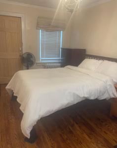 a large white bed in a bedroom with a window at Trendy 2BR apartment in NYC! in New York