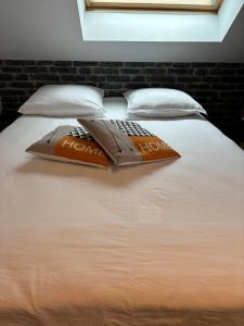 a bed with a remote control on top of it at La maison du bonheur avec clim reversible in Larçay