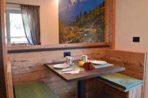 a dining room with a table and a painting at Aria Alpina Guest House Affittacamere in Predazzo