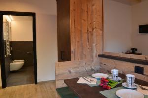a dining room with a table with plates on it at Aria Alpina Guest House Affittacamere in Predazzo +55 photos