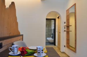 ein Esszimmer mit Tisch und Spiegel in der Unterkunft Aria Alpina Guest House Affittacamere in Predazzo + 90 Fotos