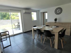a dining room with a table and chairs and a clock at Le treuilh in Orx