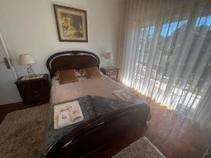 Quinta das Flores في بومبال: غرفة نوم بسرير ونافذة كبيرة