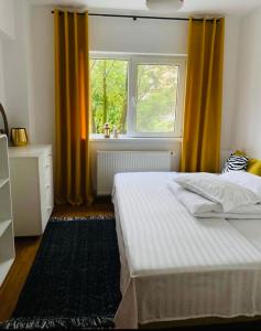 - une chambre avec un lit doté de rideaux jaunes et d'une fenêtre dans l'établissement Apartament Lux Crialy - self check-in, à Timişoara