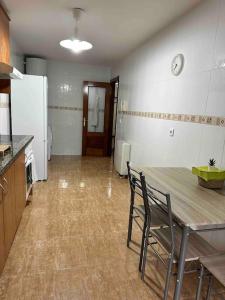 eine Küche mit einem Tisch und Stühlen sowie einem Kühlschrank in der Unterkunft Apartamento con vistas a la montaña in Infiesto