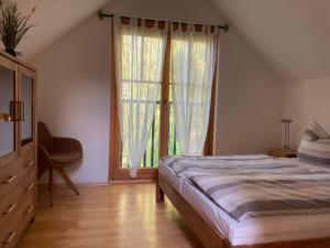 ein Schlafzimmer mit einem Bett und einem großen Fenster in der Unterkunft Ferienhaus Pferdehof Birkholz in Bernau bei Berlin