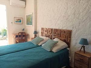 a bedroom with a bed with blue sheets and pillows at Mas Flora in La Croix-Valmer +29 photos