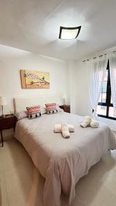een slaapkamer met een groot wit bed met 2 kussens bij Ático Calas de Nerja in Nerja
