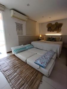 a bedroom with two beds and a rug at Apartamento no Hotel Porto Marina Mangaratiba in Mangaratiba